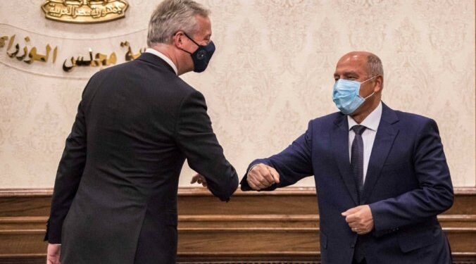 (L to R) France's Economy and Finance Minister Bruno Le Maire prepares to elbow-bump Egypt's Minister of Transportation Kamel el-Wazir during a at the prime minister's office in the capital Cairo on June 13, 2021.  / AFP / Khaled DESOUKI