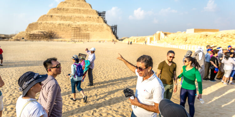 Cairo, Egypt - Nov 4th 2018 - A local guide explaining about a pyramid to a group of tourists in Cairo, Egypt