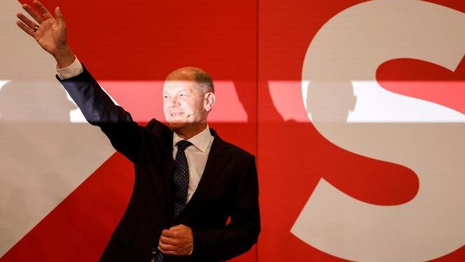 Allemagne : Leçons de démocratie 1 - Le Progrès Egyptien German Finance Minister, Vice-Chancellor and the Social Democrats (SPD) candidate for Chancellor Olaf Scholz waves on stage at the Social Democrats (SPD) headquarters after the estimates were broadcast in Berlin on September 26, 2021 after the German general elections. (Photo by Odd ANDERSEN / AFP)