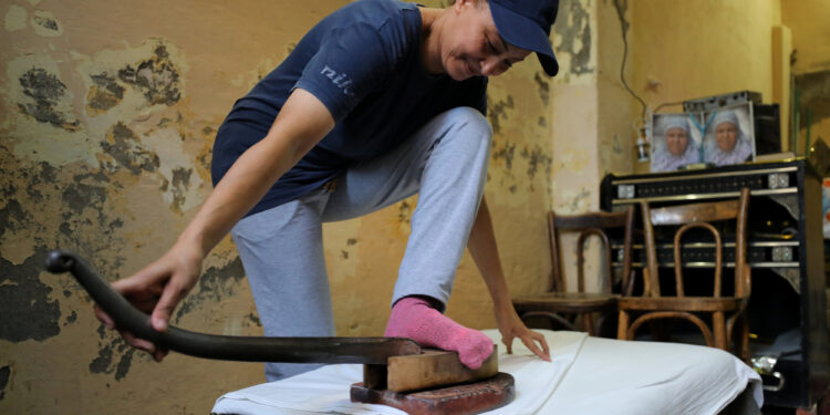 Le fer à repasser à pied, un métier qui défie le temps 1 - Le Progrès Egyptien Ebtesam Mohamed irons using her feet in Alexandria, Egypt August 10, 2017. Picture taken August 10, 2017. REUTERS/Mohamed Abd El Ghany