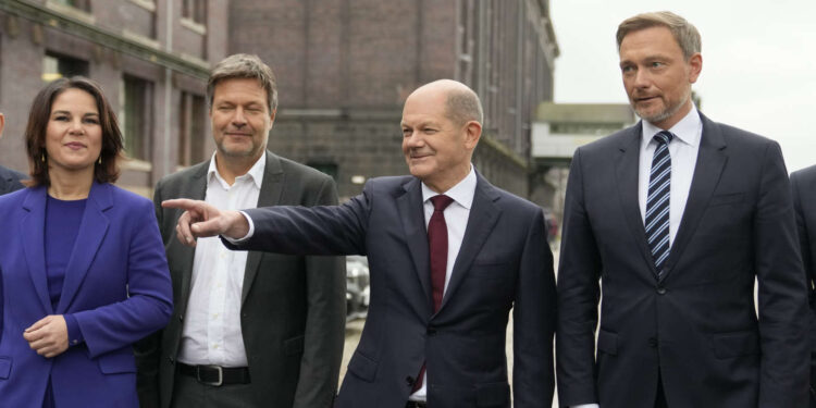 Social Democratic Party, SPD, chancellor candidate Olaf Scholz, second right, stands with the Green party leaders Annalena Baerbock, left, and Robert Habeck, second left, and the Free Democratic Party chairman Christian Lindner, right, as they arrive for a joint news conference in Berlin, Germany, Wednesday, Nov. 24, 2021. After weeks of negotiations the leaders of the three parties present a coalition contract for a new German government. (AP Photo/Markus Schreiber)