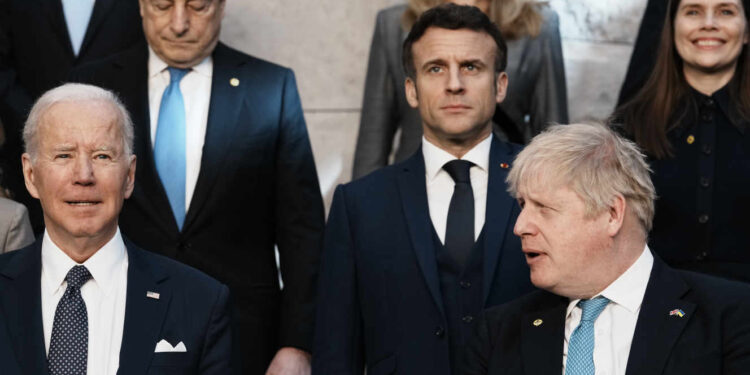 British Prime Minister Boris Johnson, front right, looks toward U.S. President Joe Biden, front left, at a group photo during an extraordinary NATO summit at NATO headquarters in Brussels, Thursday, March 24, 2022. As the war in Ukraine grinds into a second month, President Joe Biden and Western allies are gathering to chart a path to ramp up pressure on Russian President Vladimir Putin while tending to the economic and security fallout that's spreading across Europe and the world. (AP Photo/Thibault Camus)