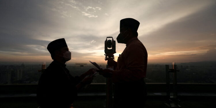 Silhouettes of Malaysia's Islamic Authority's officers and a theodolite which they use to perform "rukyah", the sighting of the new moon which signals the start of the holy month of Ramadan, are seen in Kuala Lumpur, Malaysia, April 1, 2022. REUTERS/Hasnoor Hussain     TPX IMAGES OF THE DAY