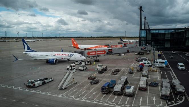 <strong>Grève à l'aéroport de Berlin pour réclamer des salaires plus élevés </strong> 1 - Le Progrès Egyptien Aircraft of regional Turkish airline Anadolujet and British low-cost airline Easyjet are seen through a window as they are parked on the tarmac of Berlin Brandenburg Airport Willy Brandt (BER) in Schoenefeld, southeast of the German capital on July 9, 2022. (Photo by John MACDOUGALL / AFP)