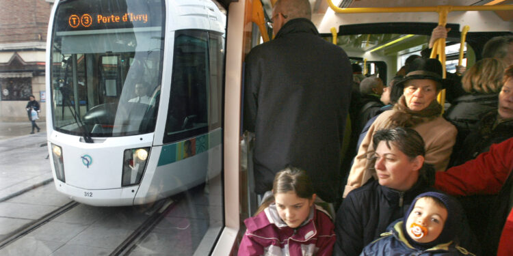 People take a free ride in the new Parisian tramway a day after its inauguration in Paris December 17, 2006. Trams returned to Paris on Saturday after a 69-year gap, with the inauguration of a new commuter service around part of the city's southern periphery. The "Tramway of the Marshals" traces a 8 km (5 mile) arc along the southern perimeter, following a series of boulevards named after Napoleon's generals.  REUTERS/Charles Platiau  (FRANCE) - RTR1KICU