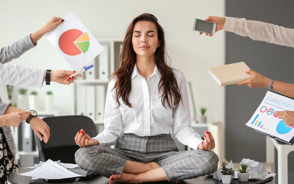 Businesswoman with a lot of work to do meditating in office