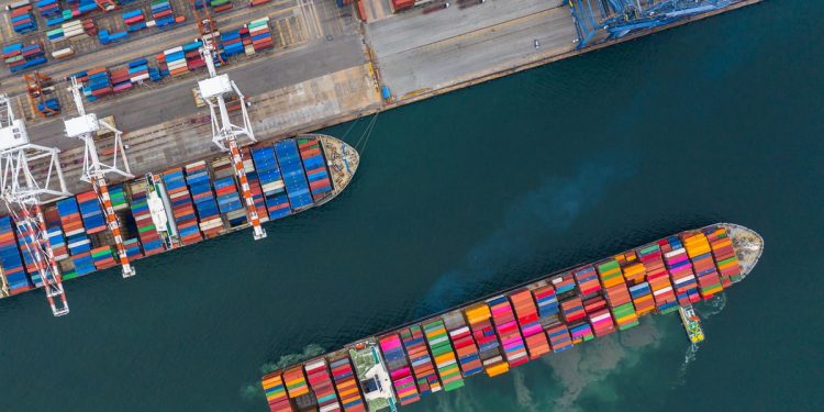 Aerial view cargo ship terminal, Unloading crane of cargo ship terminal, Aerial view industrial port with containers and container ship.