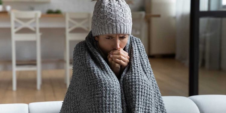 Des pluies pas loin du Caire... Des conseils pour affronter le froid 1 - Le Progrès Egyptien Unwell millennial female renter in hat and blanket sit in cold living room suffer from air conditioner lack. Unhealthy young Caucasian woman struggle from chill freeze at home. No heating concept.