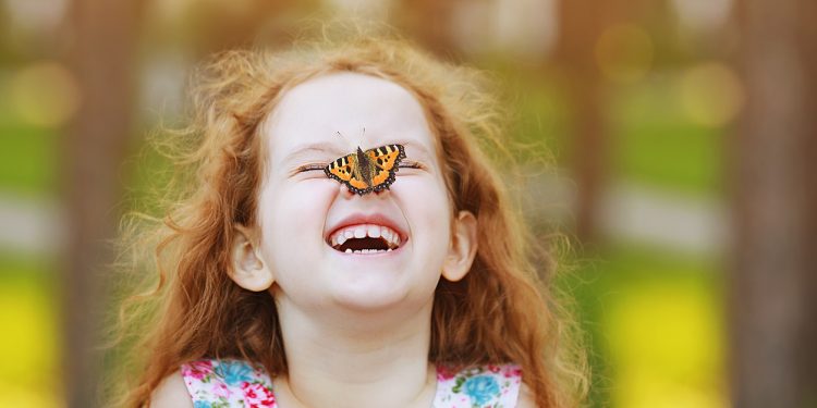 Rire a ses bienfaits 1 - Le Progrès Egyptien Funny laughing curly girl with a butterfly on his nose. Healthy smile with white teeth. Free breathing concept.