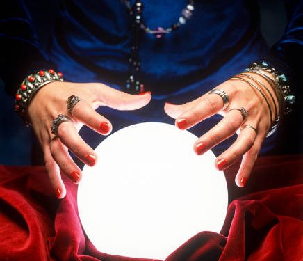 close up on female gypsy hands on a glowing crystal ball