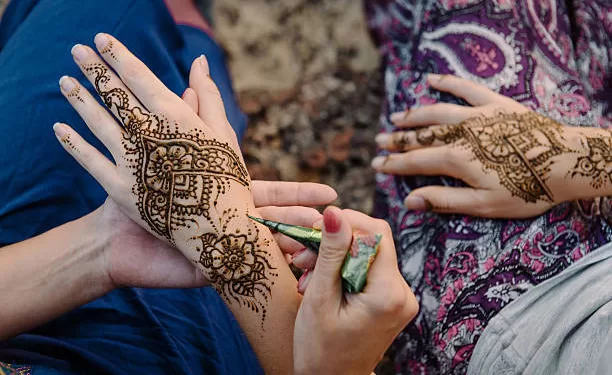 Le henné entre au patrimoine immatériel de l’UNESCO 1 - Le Progrès Egyptien Applying henna tattoo on women hands. Mehndi is traditional Indian decorative art. Close-up, top view