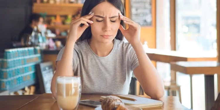 Young female sitting in a cafe indoors rest sick