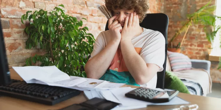 Portrait of caucasian unset and despair man watching financial and economical graphs during coronavirus quarantine, problems. Worldwide crisis.