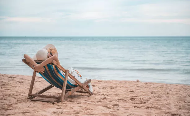 Il est temps d'adopter une stratégie de relaxation estivale 1 - Le Progrès Egyptien Beautiful young asian woman with hat arm up relaxing on beach chair, Summer happy beach vacation concept.